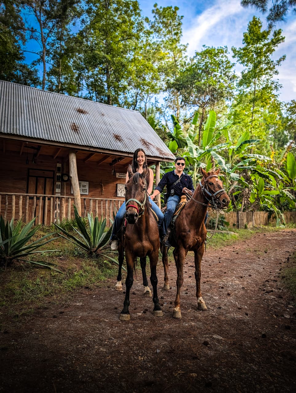Dos jinetes a caballo en el camino de la granja de Casa Misterio Verde